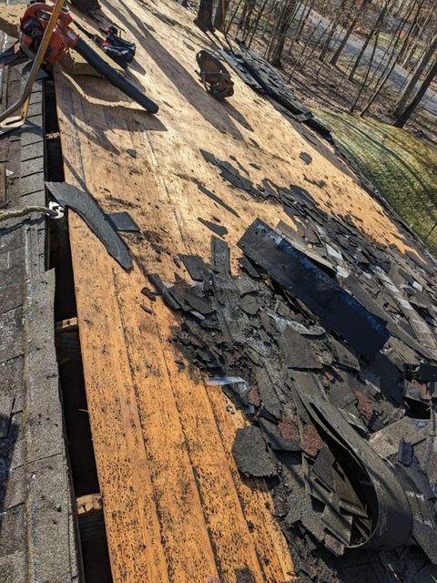 A roof with a lot of slate being removed from it