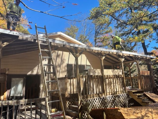 Two men are working on the roof of a house.