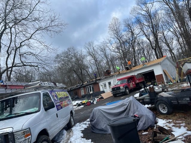 A white van is parked in the snow in front of a house.