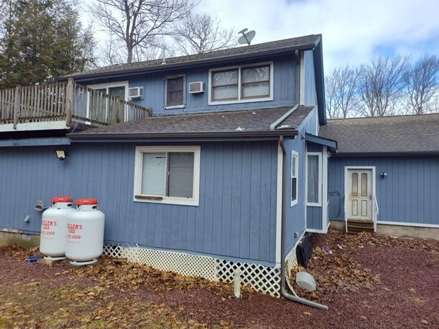 A blue house with two propane tanks in front of it