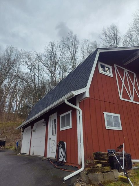 A red barn with a black roof and white trim