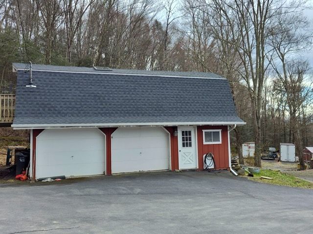 A red and white garage with a blue roof