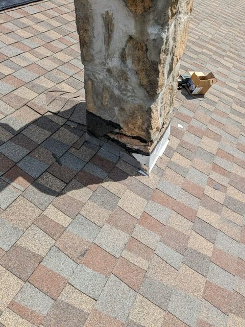 A brick walkway with a stone column in the middle