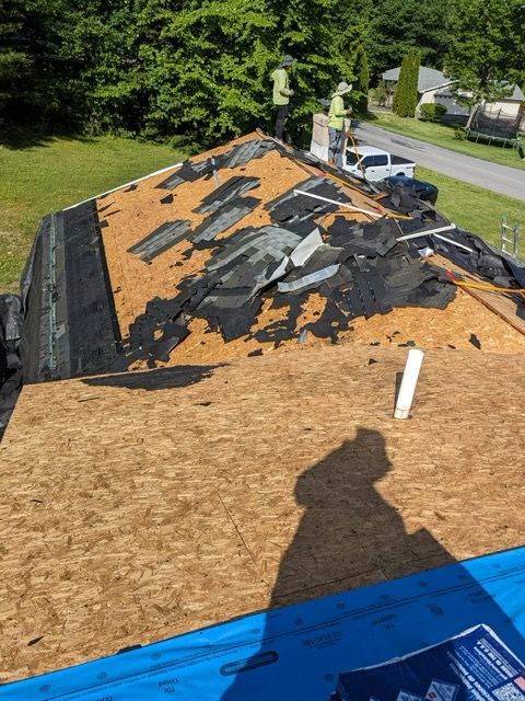 Two men are working on a roof that is being remodeled