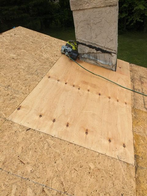 A chimney is sitting on top of a wooden roof.