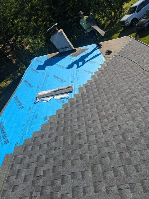 An aerial view of a roof with shingles being installed.
