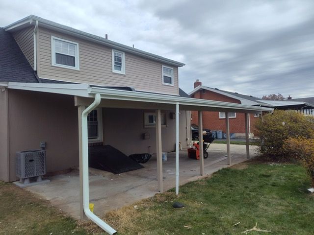 A house with a porch and a gutter on the side of it.