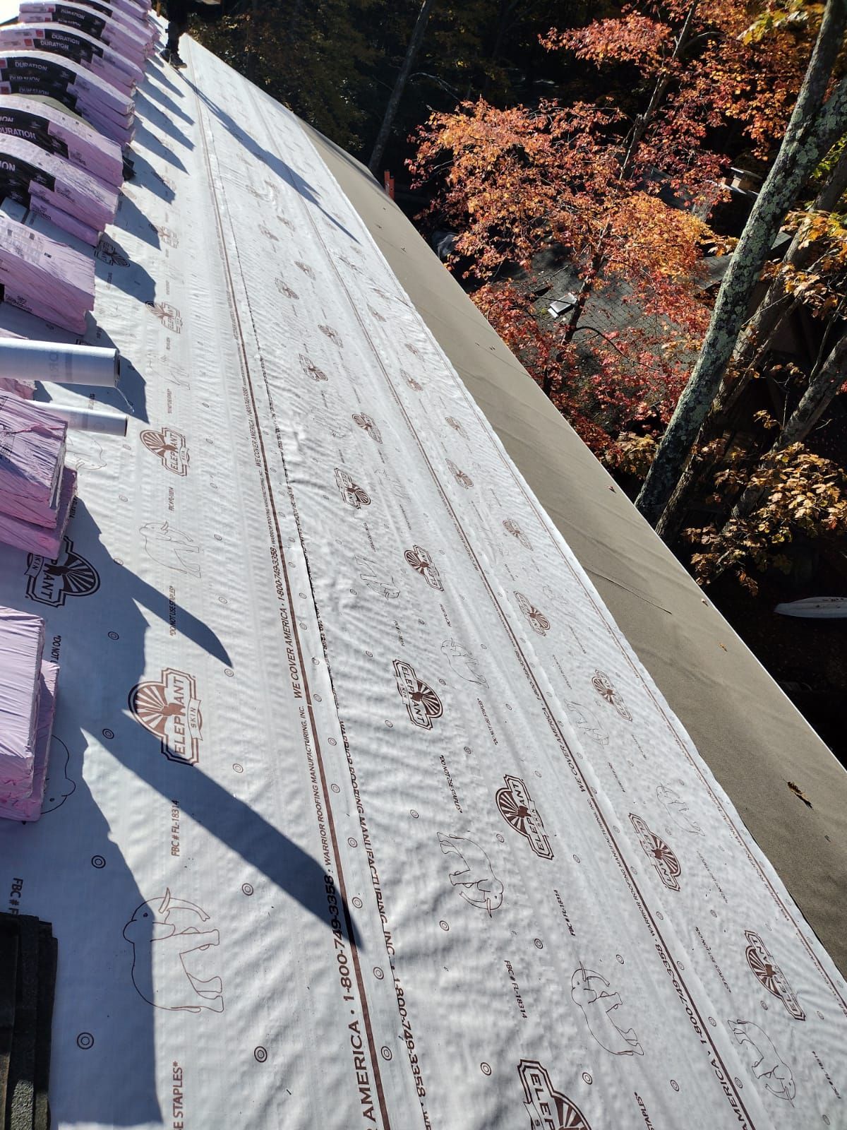 A roof with a lot of foam on it and trees in the background.
