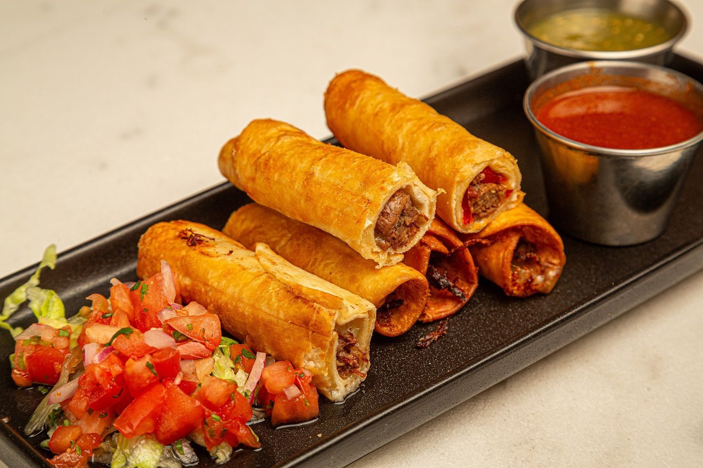 A close up of a plate of food with salsa and sauce on a table.