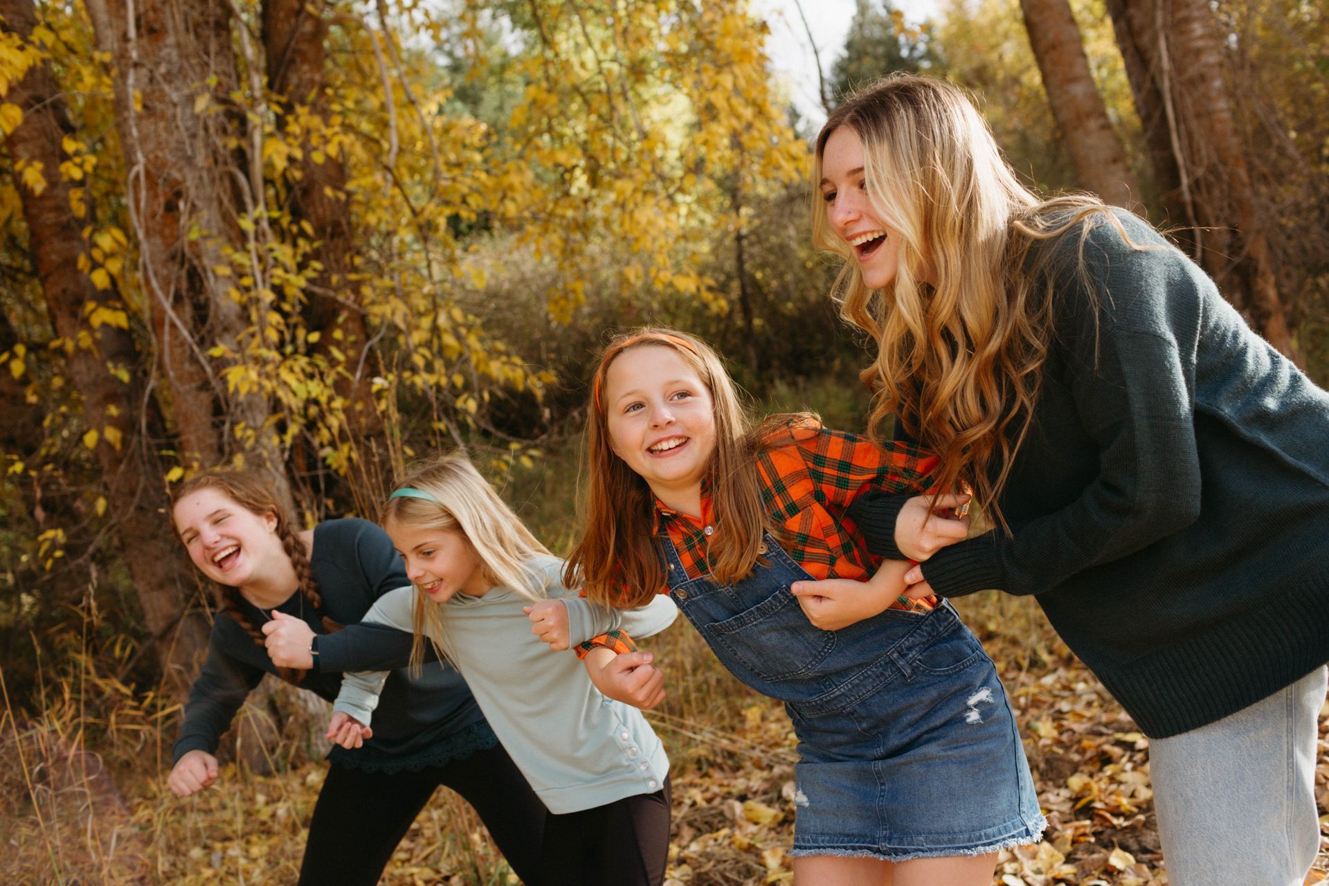 A group of young girls are playing in the woods.