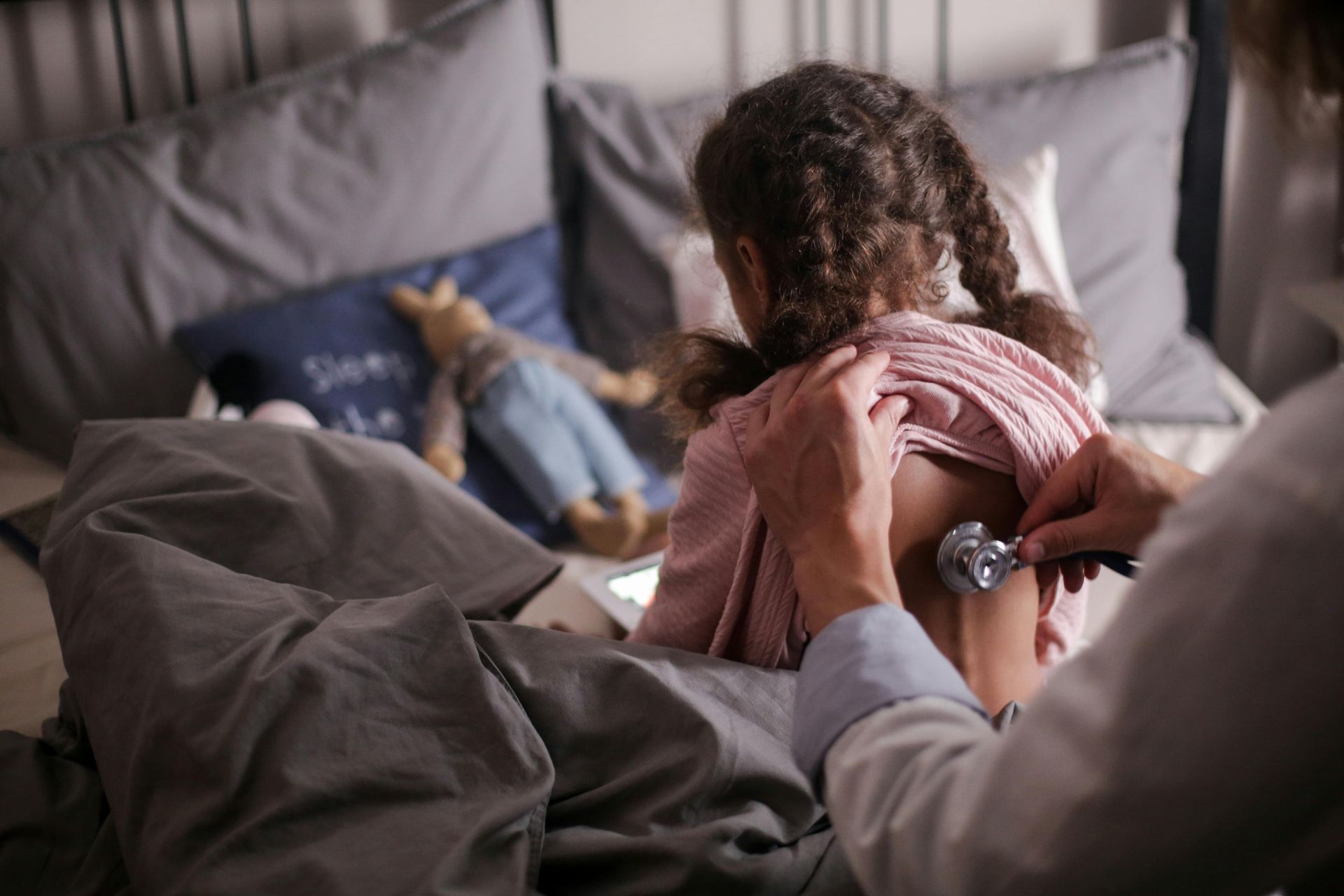 A little girl is being examined by a doctor with a stethoscope.