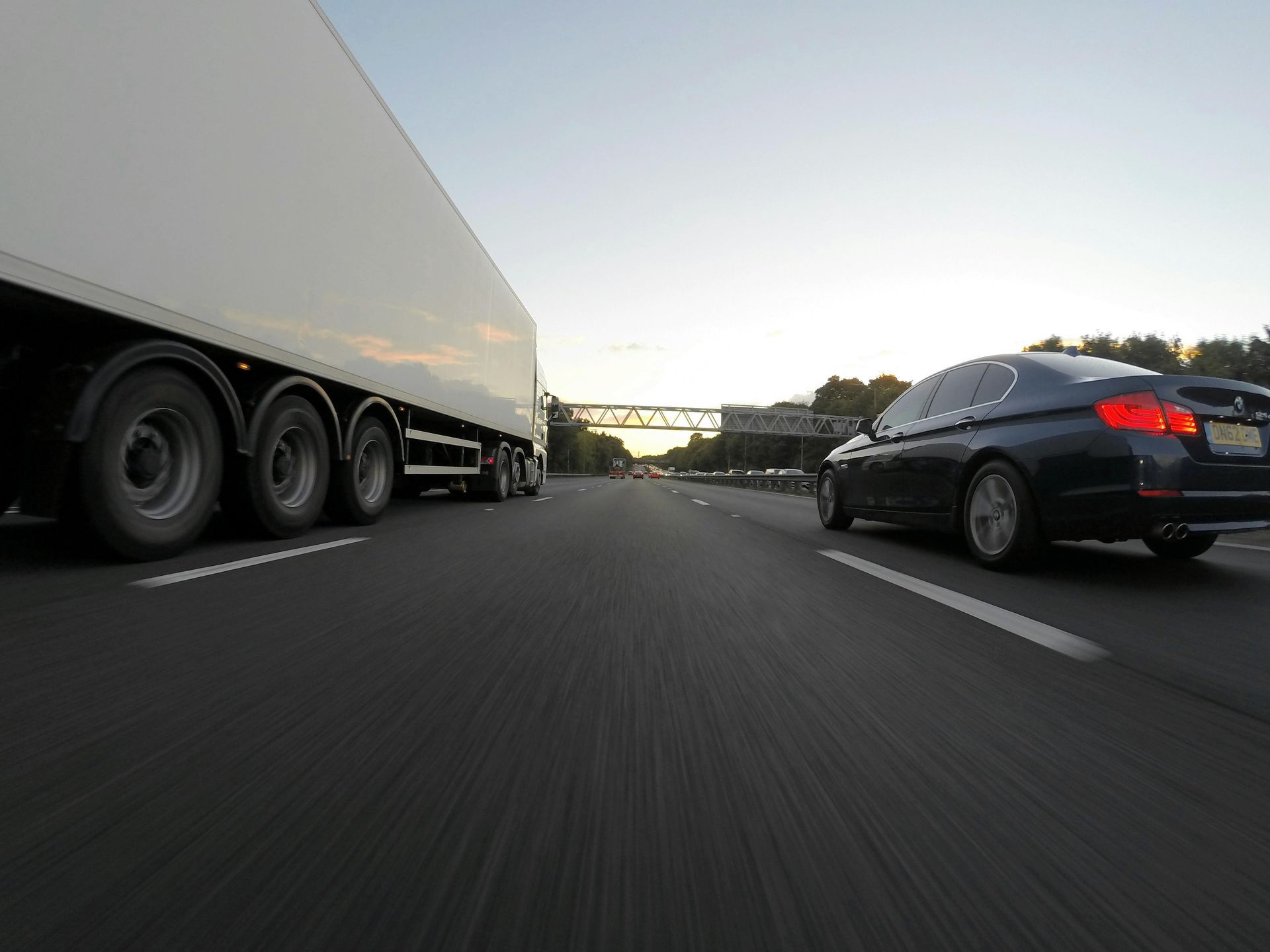 A truck and a car are driving down a highway.