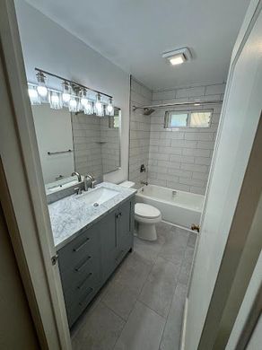 A bathroom with a sink , toilet , bathtub and mirror.