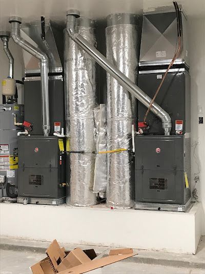 A room with a lot of pipes and a box on the floor.