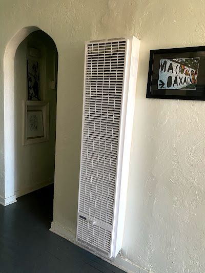 There is a picture on the wall above the heater.