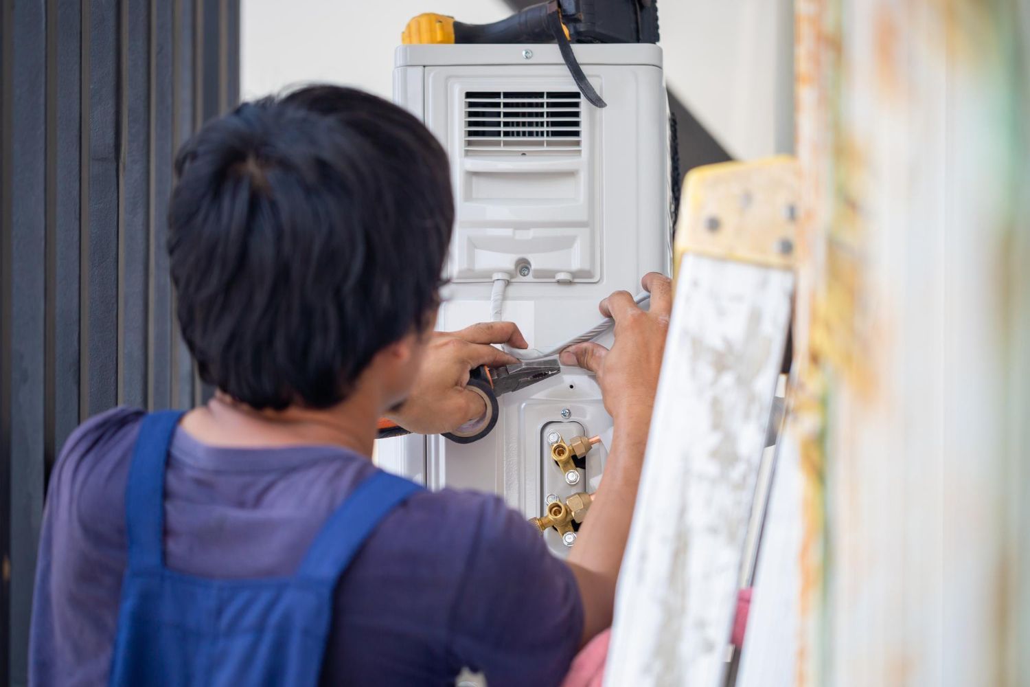 A technician from Reid Heating & Air performing an emergency HVAC installation services.