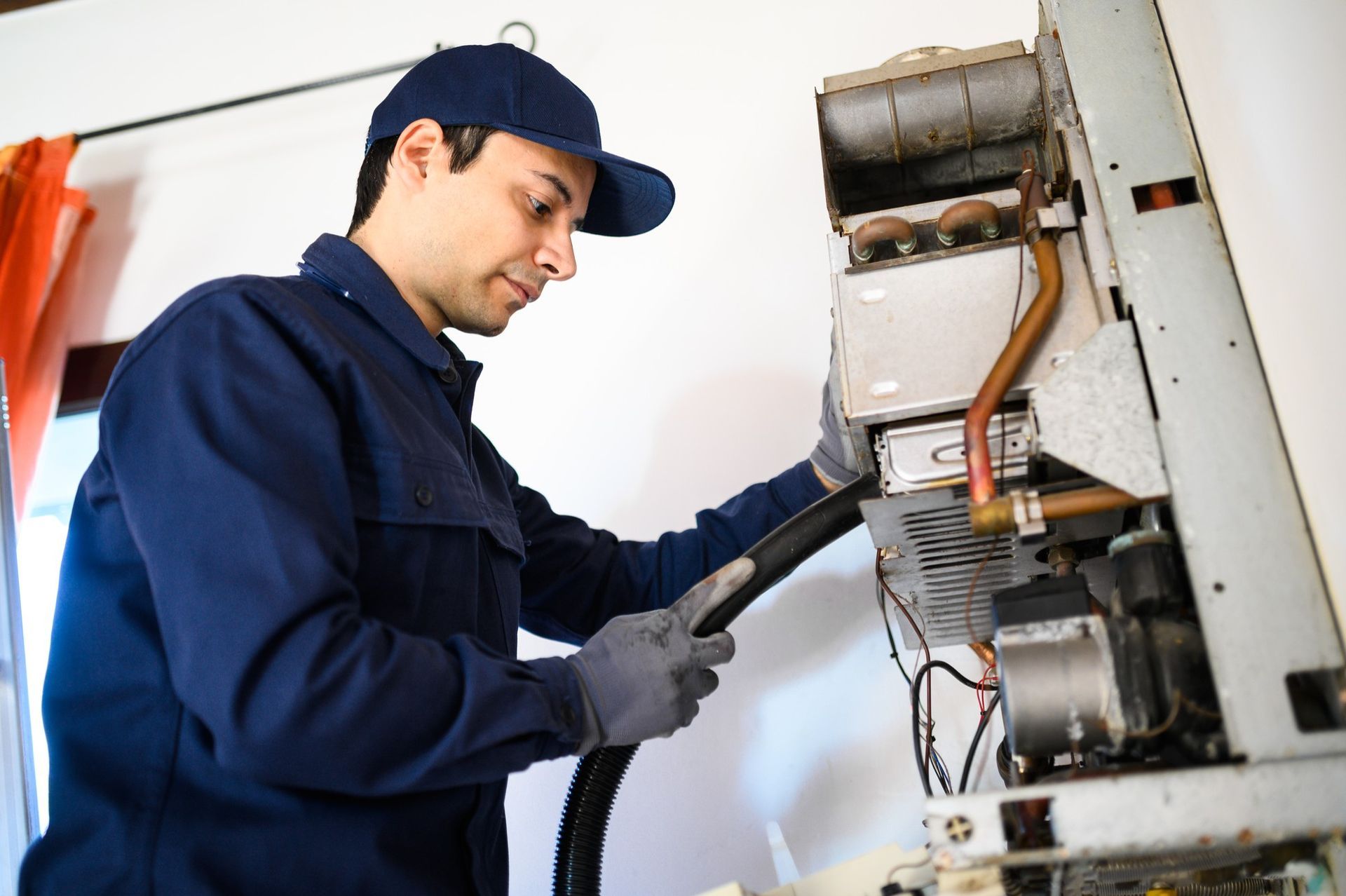 A technician from Reid Heating & Air performing a commercial heating services