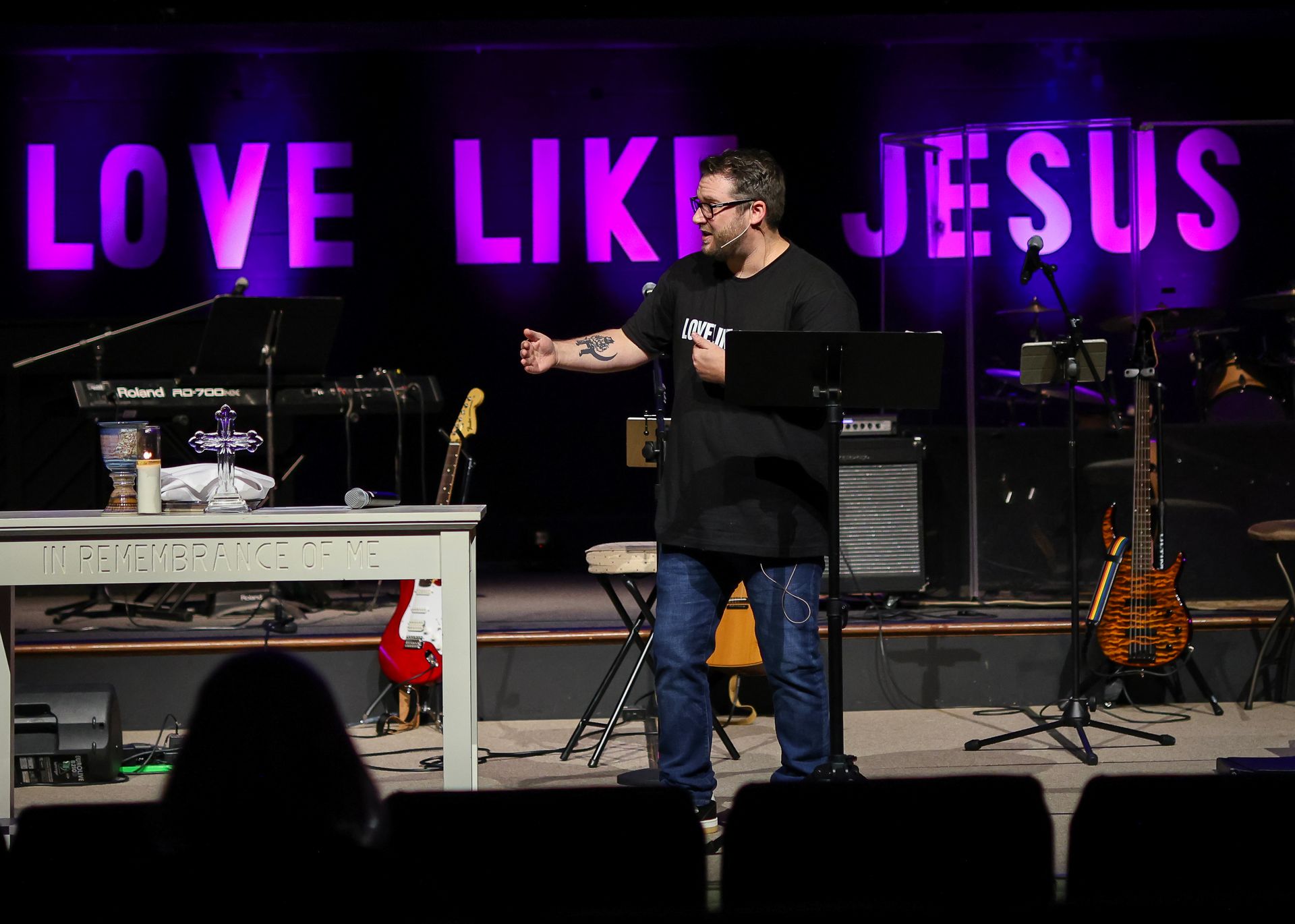 Worship leader wearing a cap and playing guitar.