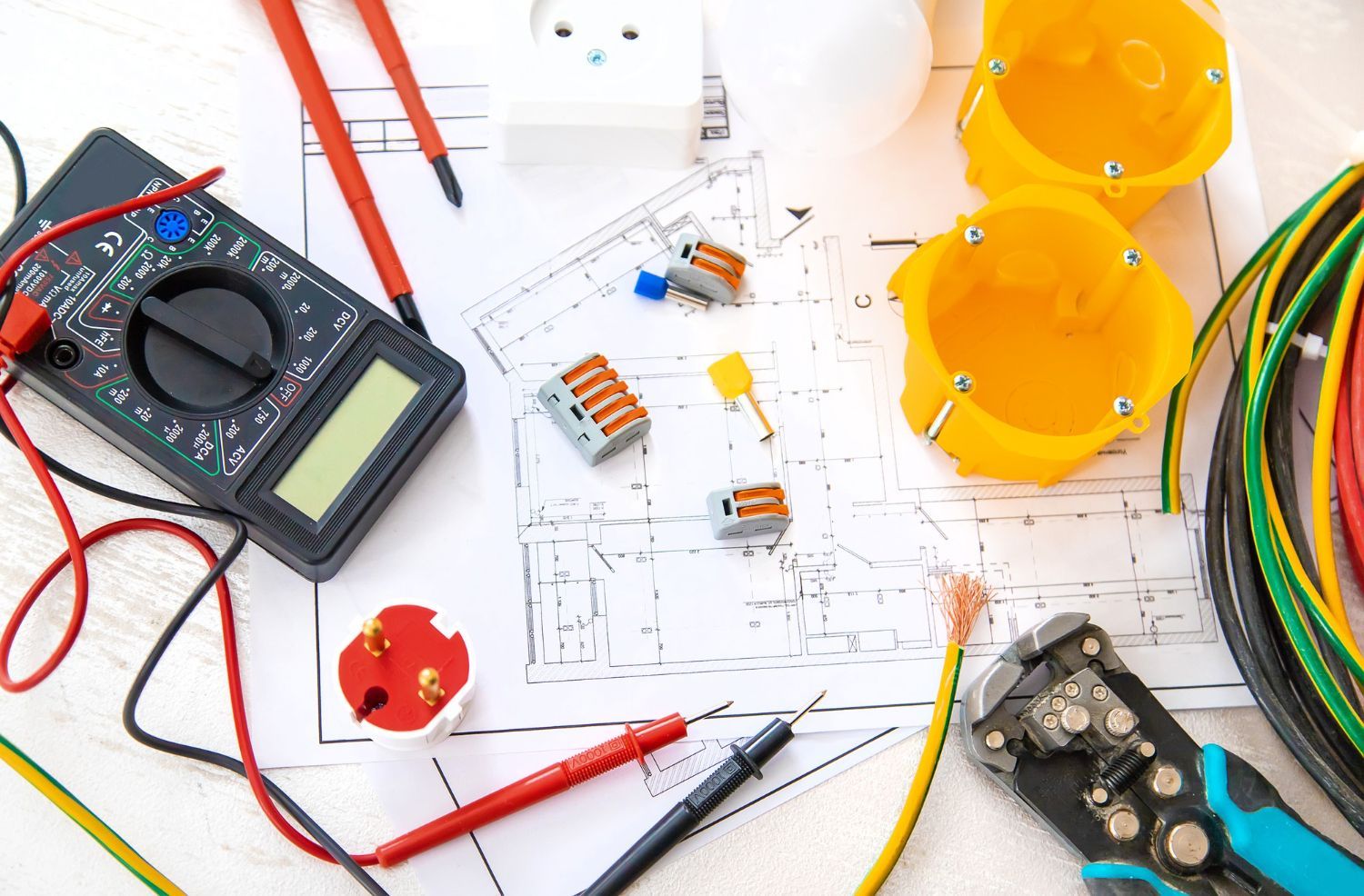 A bunch of electric tools are sitting on top of a blueprint.