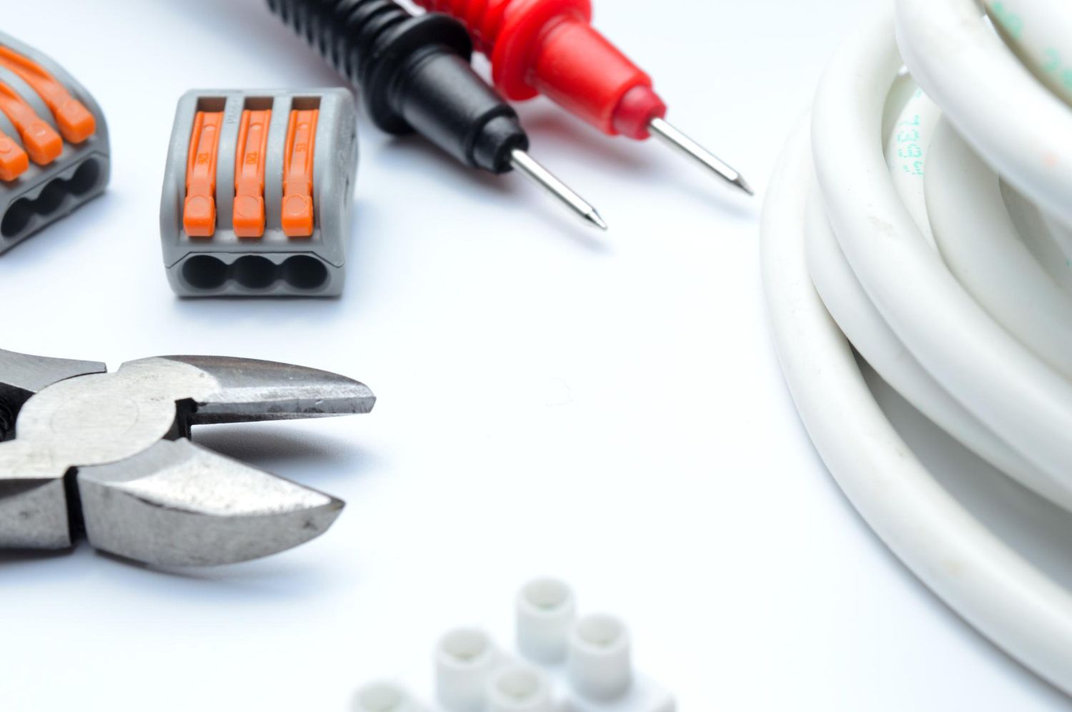 A pair of pliers sitting next to a bunch of wires