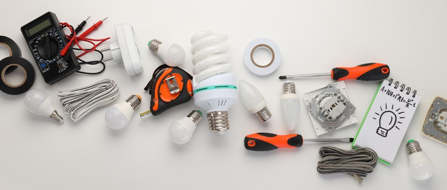 A bunch of electrical tools and bulbs on a table.