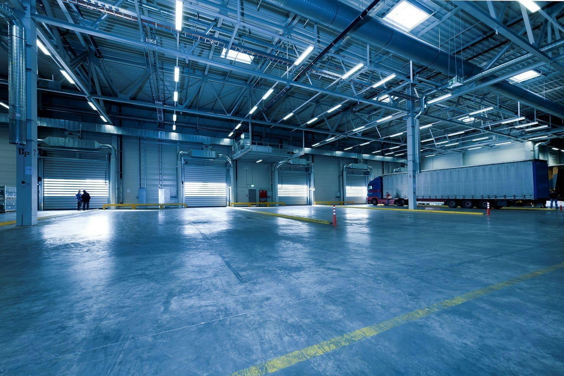 An empty warehouse with a truck parked in it