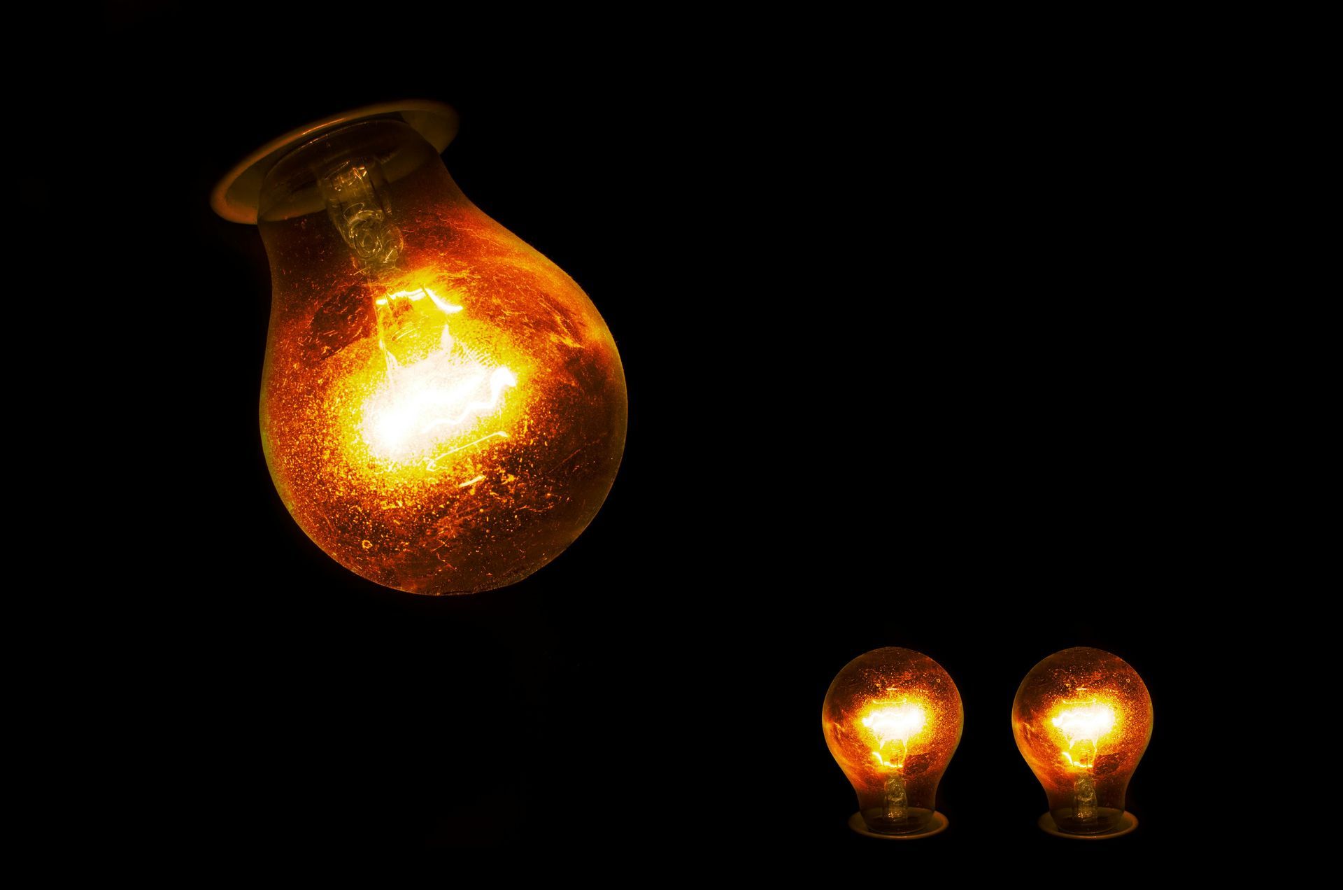 Two light bulbs are lit up on a black background.