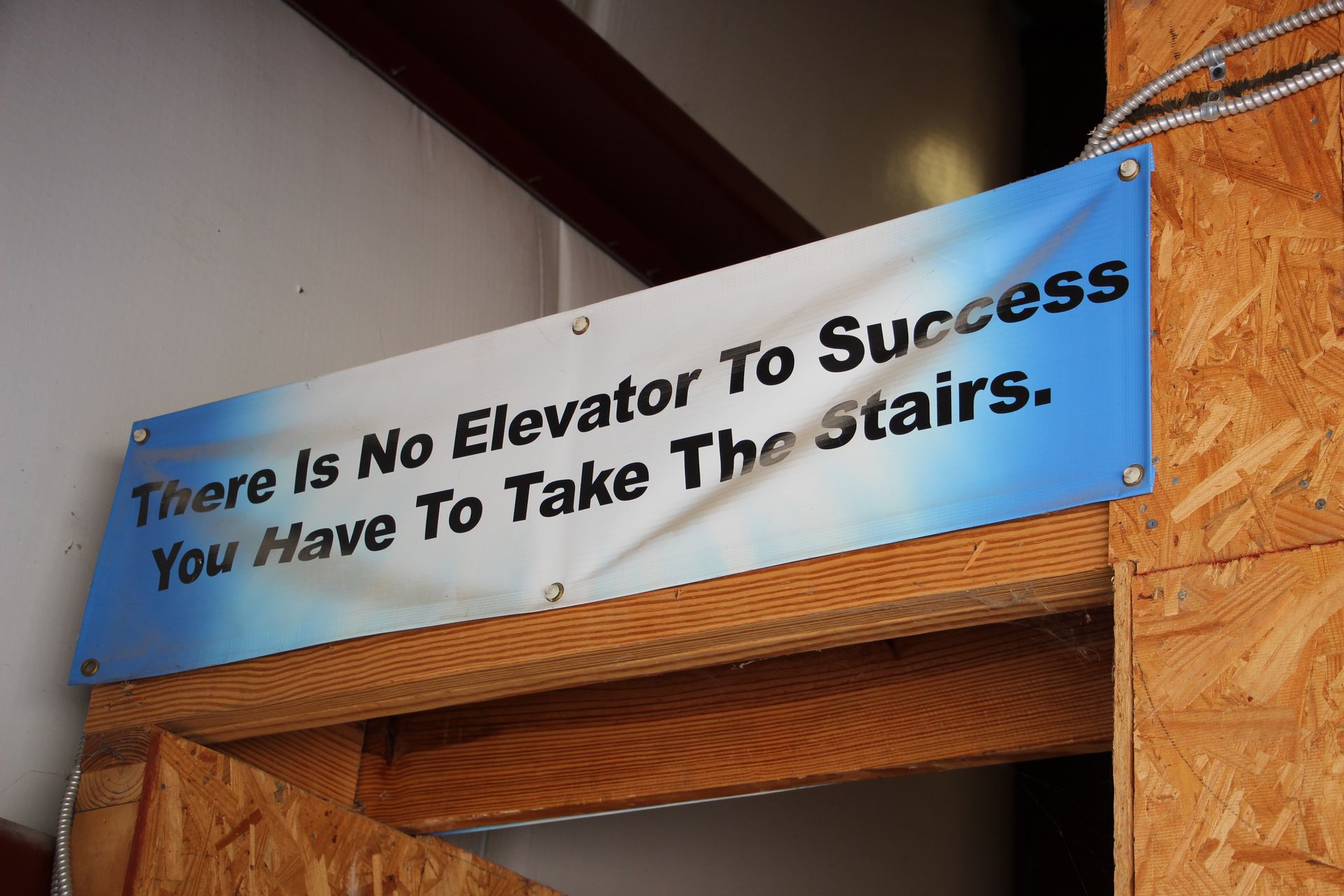 A sign that says there is no elevator to success you have to take the stairs