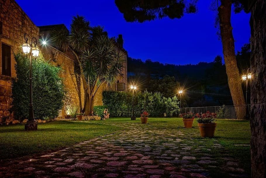 A cobblestone path leading to a building at night.