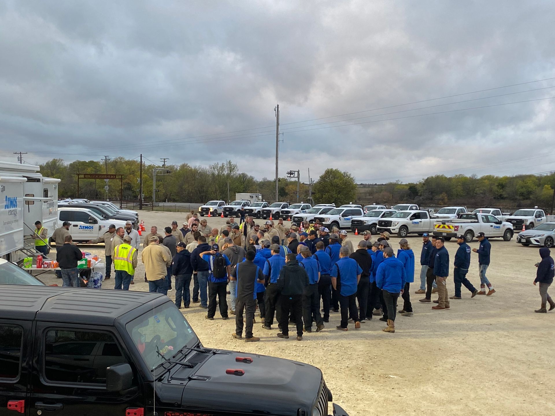 A large group of people are standing in a parking lot.