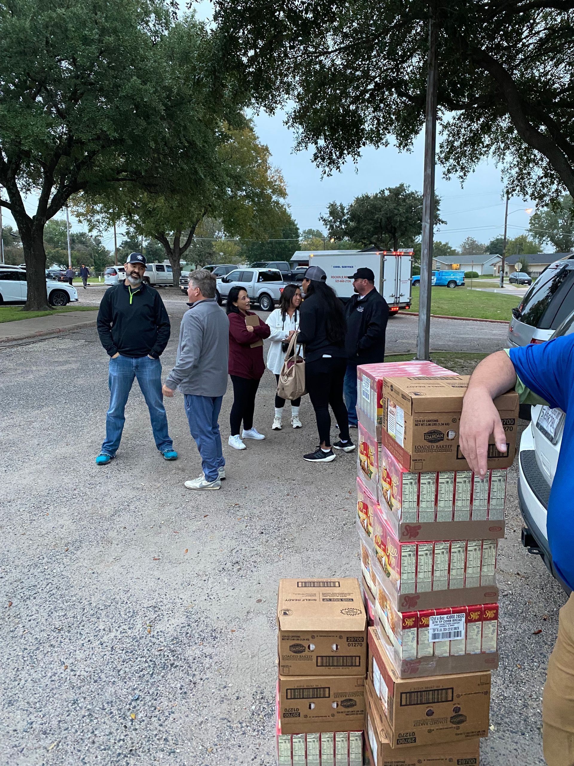 A group of people are standing around a pile of boxes.