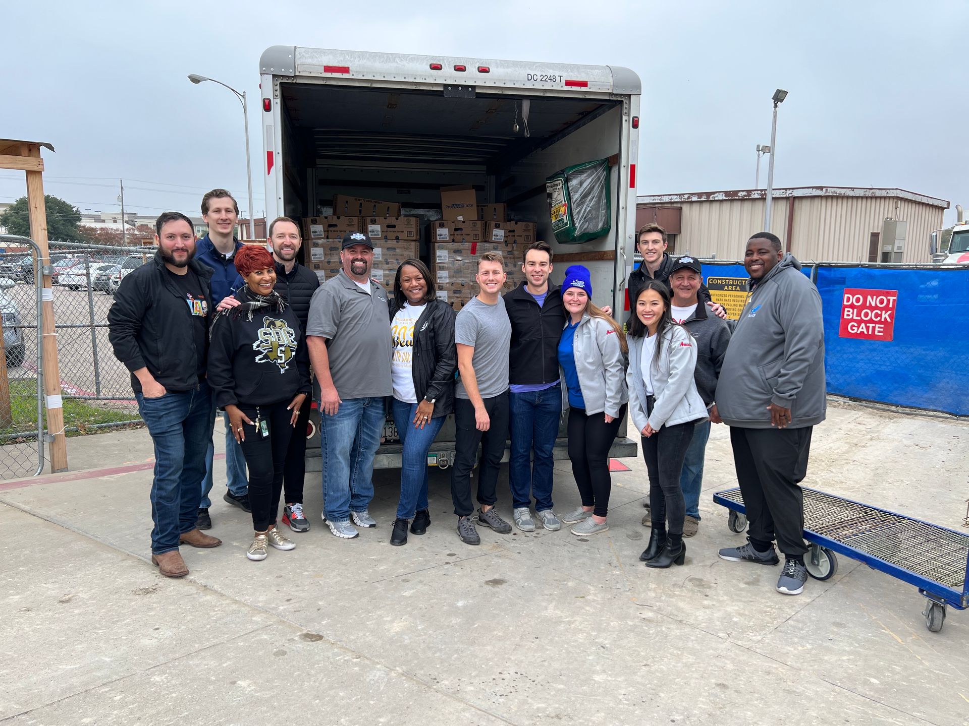 A group of people are standing in front of a truck filled with boxes.