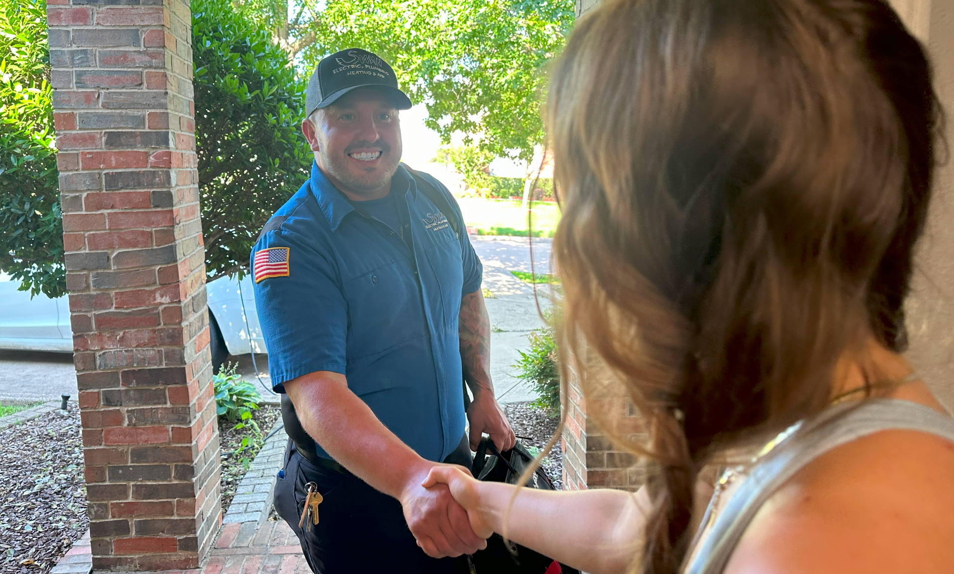 A man is shaking hands with a woman on a porch.