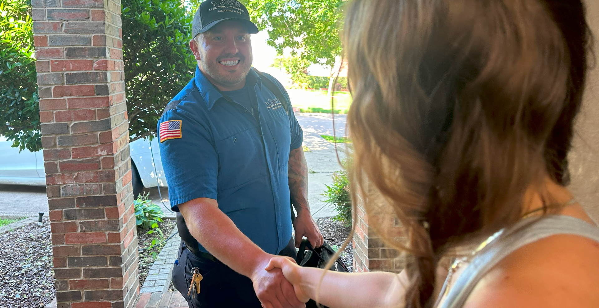 A man is shaking hands with a woman on a porch.