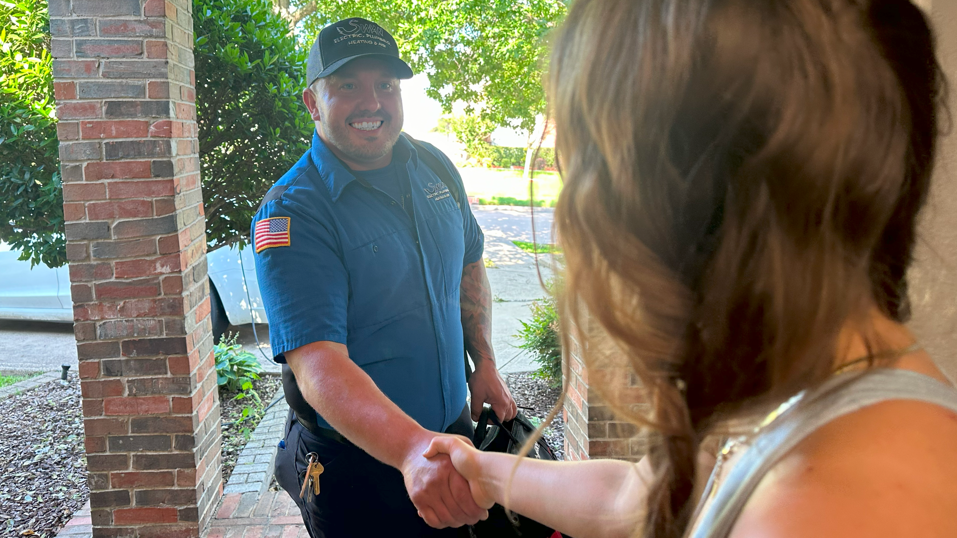 A man is shaking hands with a woman on a porch.