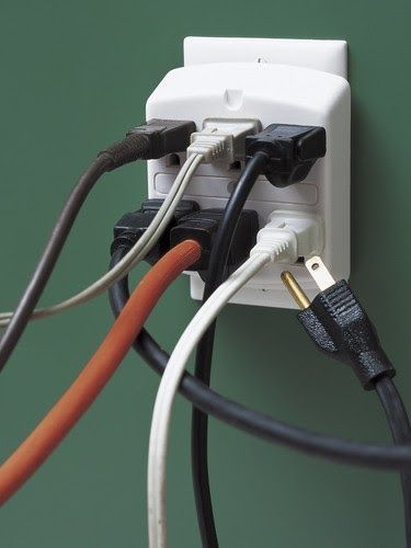 A bunch of wires are plugged into a wall socket