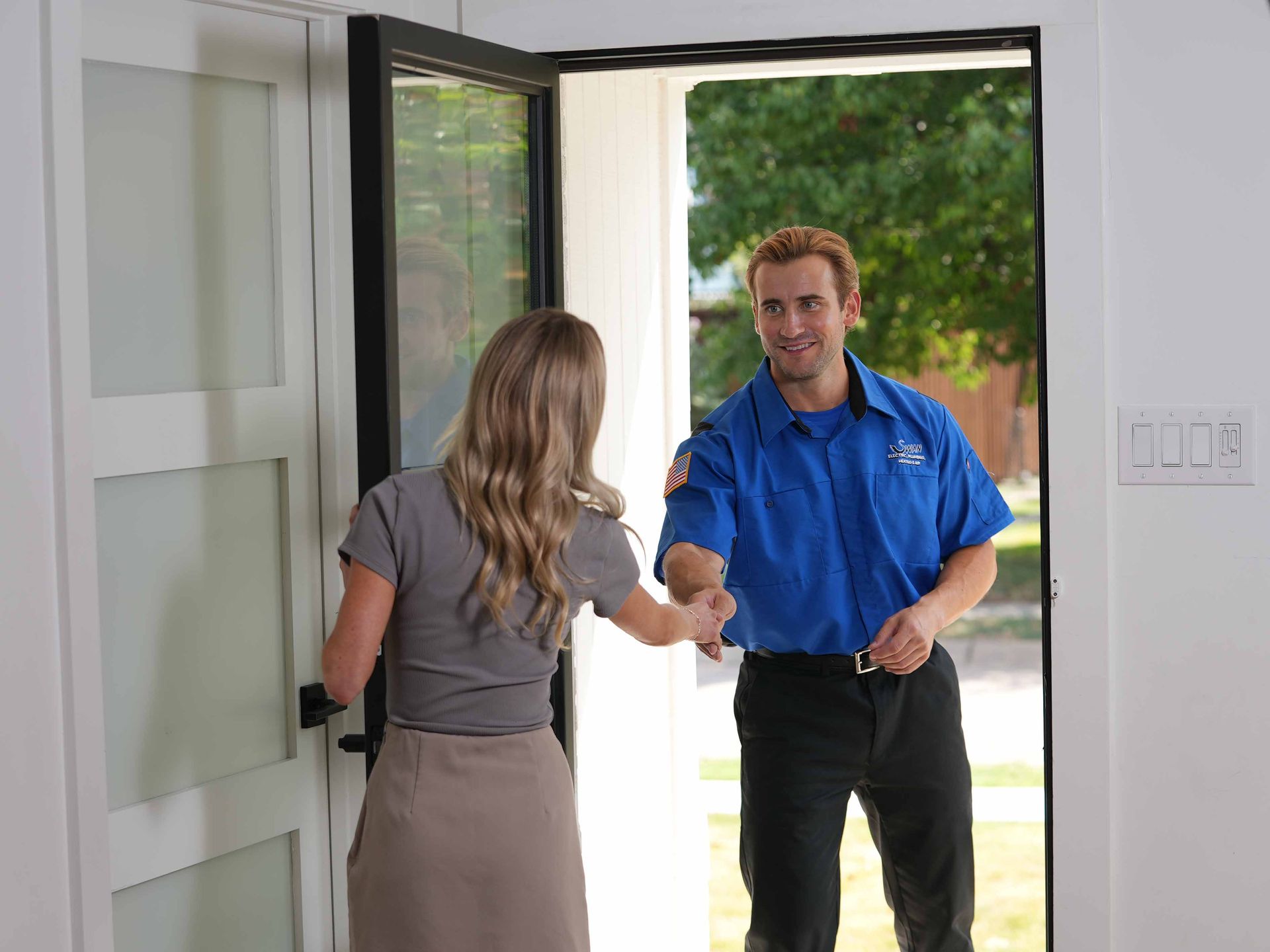A man is shaking hands with a woman on a porch.
