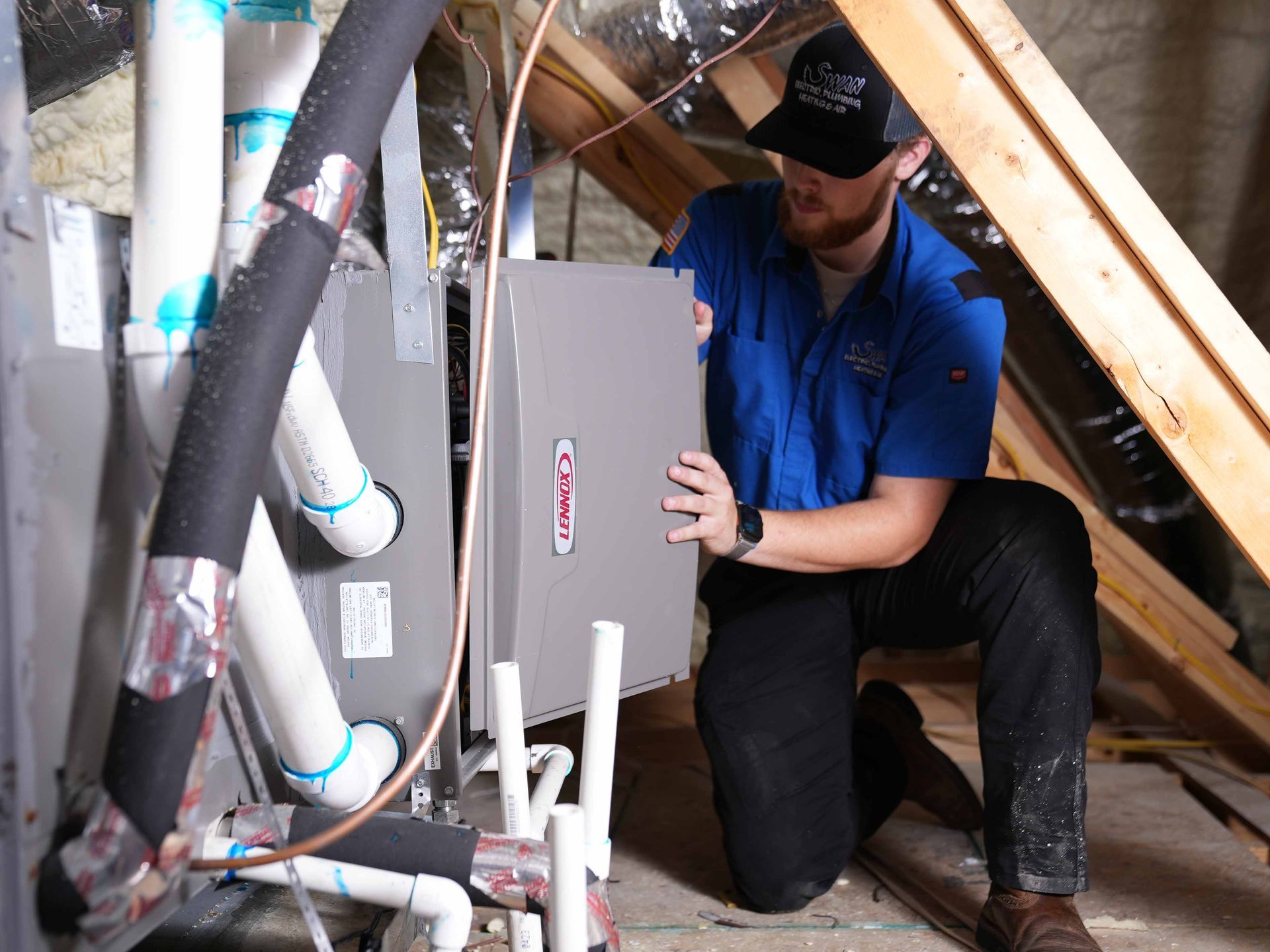 Two men are standing next to each other in front of an air conditioner.