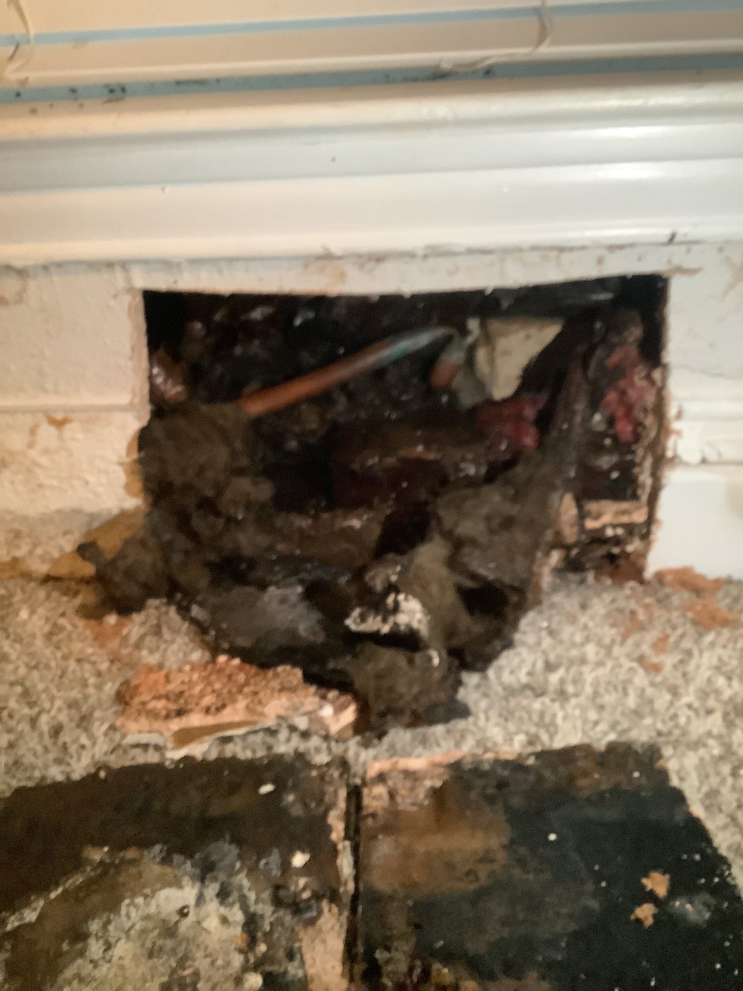 The access point where we opened the floor to fix the leak and reroute the water line from the bathroom manifold to the shower