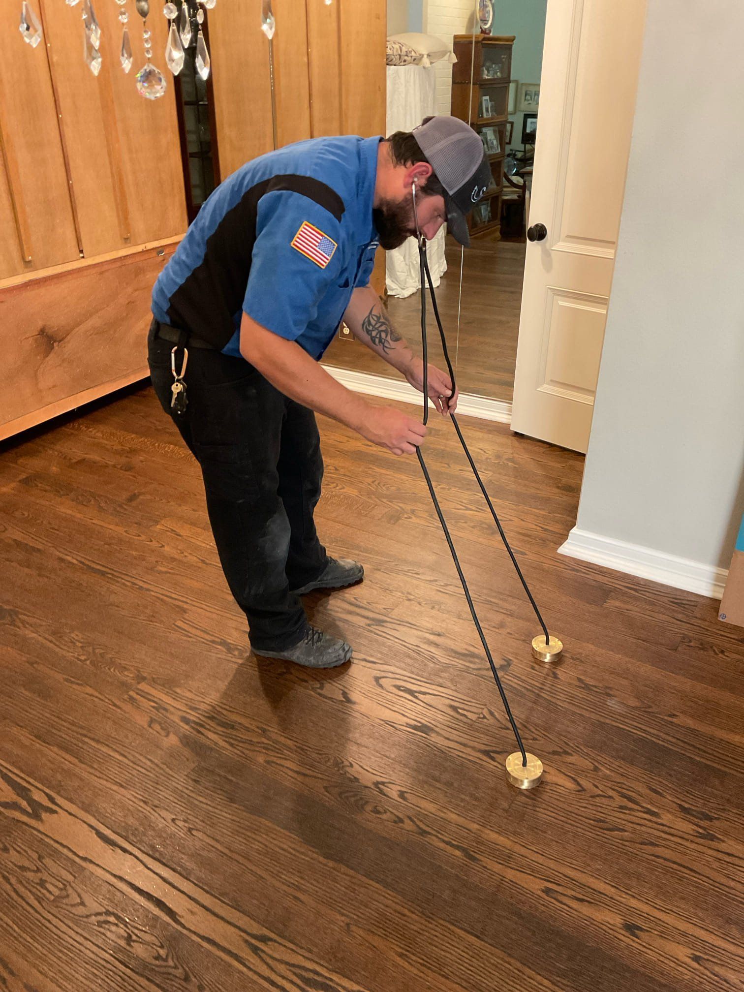 A man in a blue shirt is standing on a wooden floor.