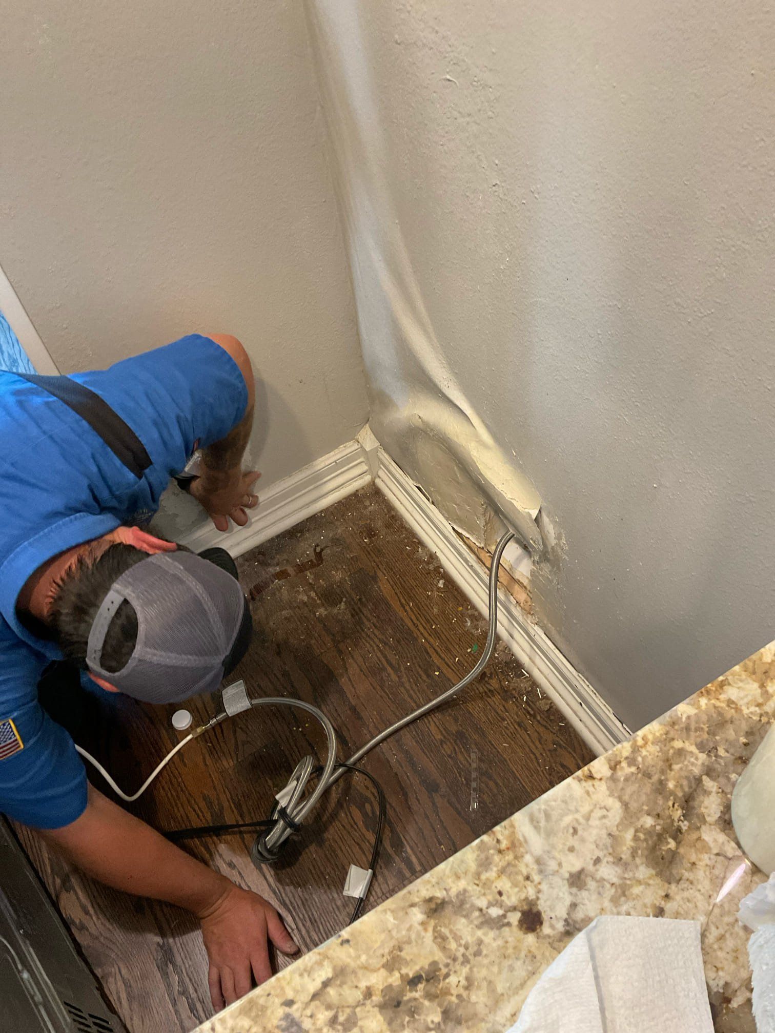 A man in a blue shirt is working on a slab leak repair