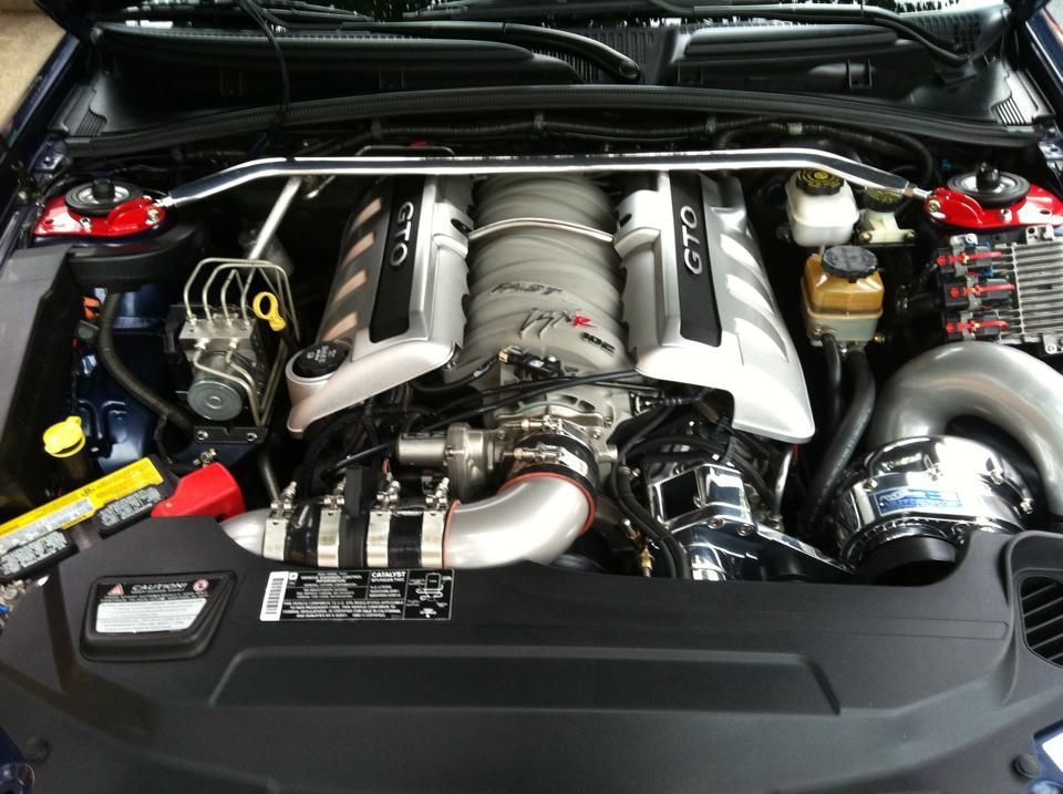 Blue car engine bay with a silver engine, 
