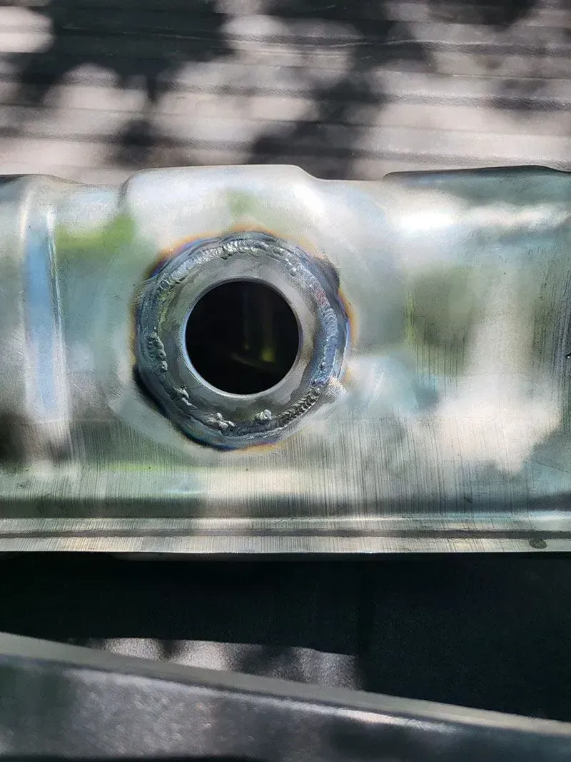 A close up of a metal pipe with a hole in it.