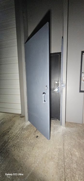 A large door is open in a dark room.