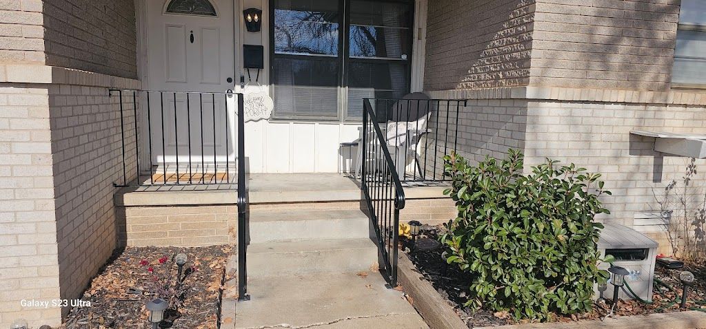 A brick house with a walkway leading to the front door