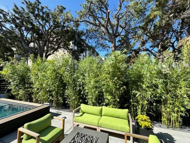A patio with green furniture and a fire pit
