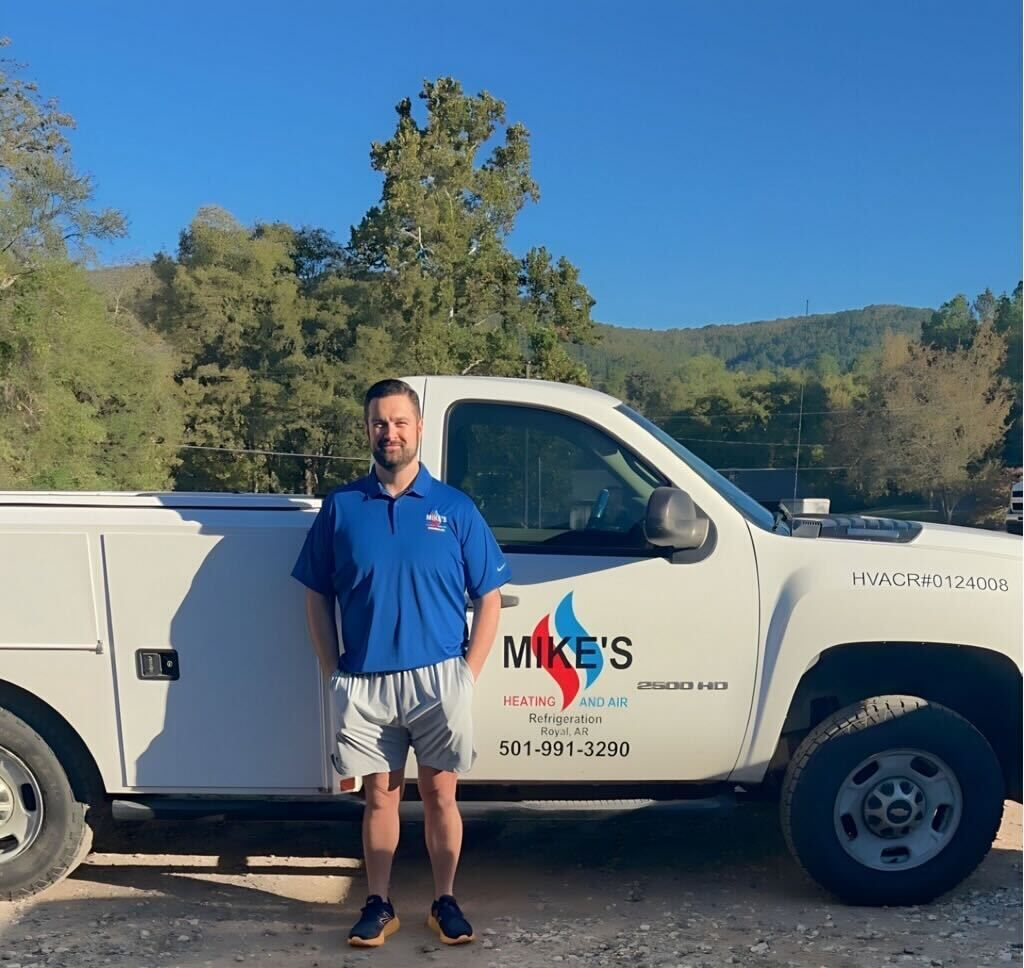 A man is standing in front of a mikes truck