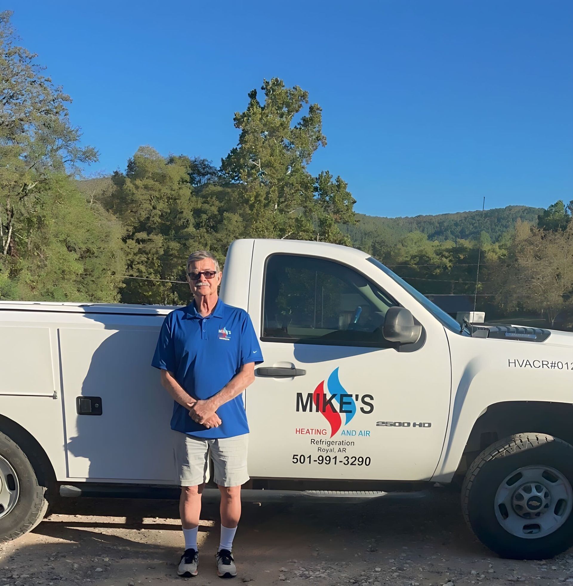 A man is standing in front of a mike 's truck