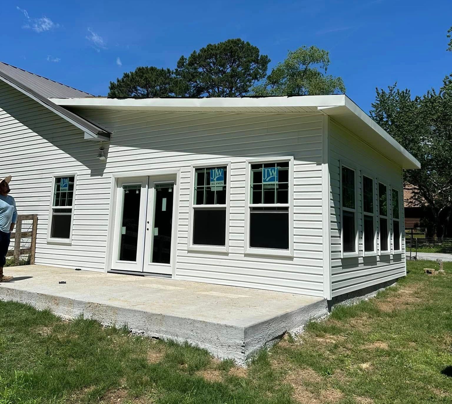 A white house with a lot of windows is being built.