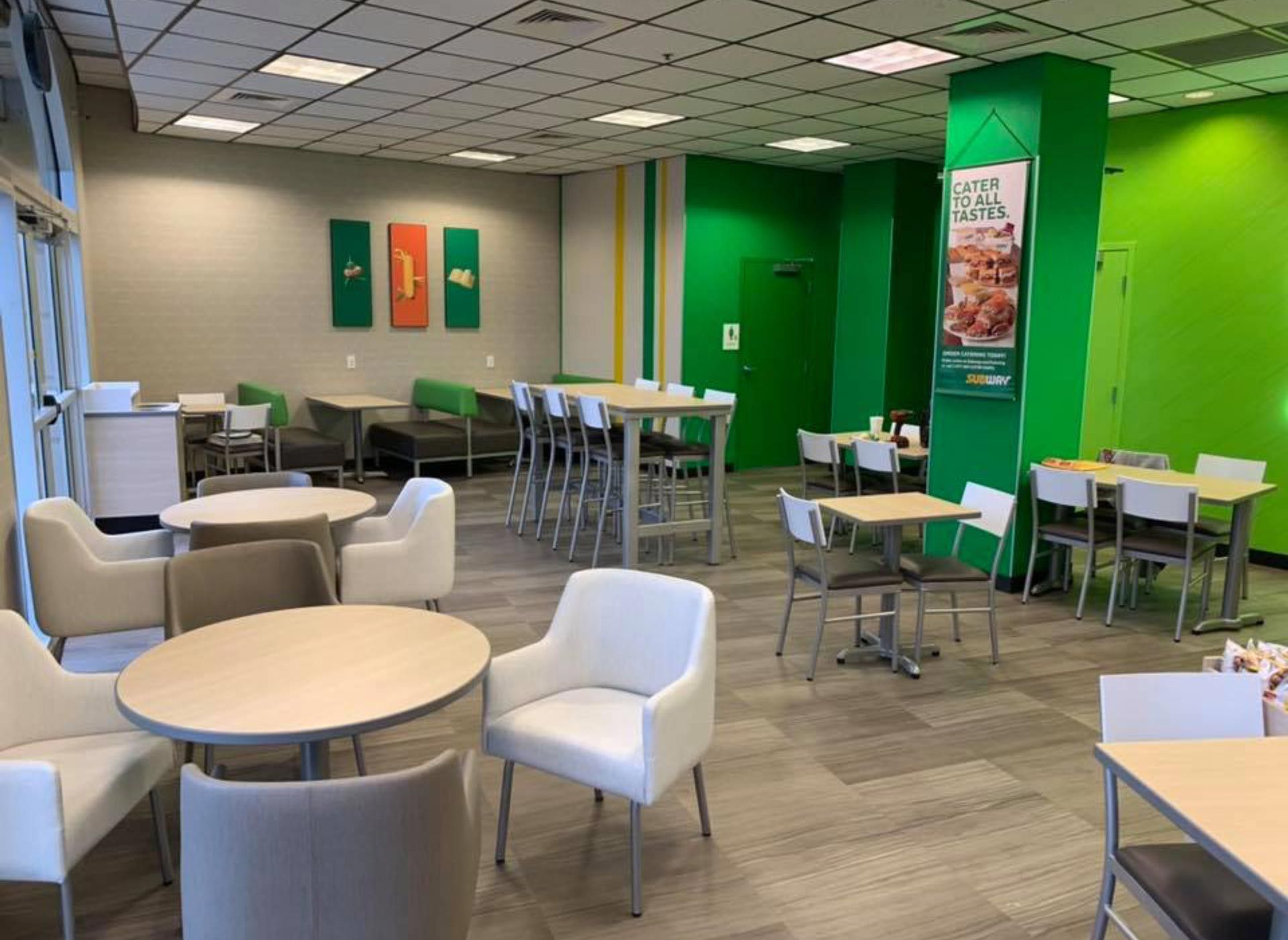 A restaurant with tables and chairs and a green wall